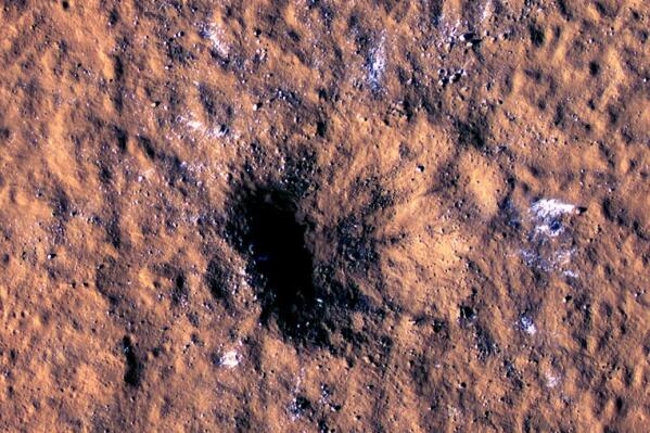 In this image made available by NASA on Thursday, Oct. 27, 2022, boulder-size blocks of water ice are seen around the rim of an impact crater on Mars, as viewed by the High-Resolution Imaging Science Experiment (HiRISE camera) aboard NASA's Mars Reconnaissance Orbiter. The crater was formed Dec. 24, 2021, by a meteoroid strike in the Amazonis Planitia region. (NASA/JPL-Caltech/University of Arizona via AP)