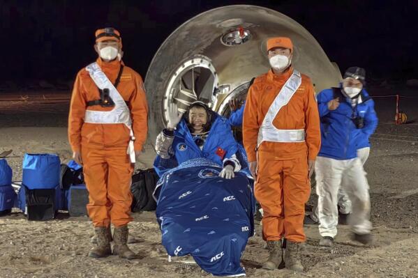 In this photo released by Xinhua News Agency, astronaut Chen Dong waves as he sits outside the re-entry capsule of the Shenzhou-14 manned space mission after it lands successfully at the Dongfeng landing site in northern China's Inner Mongolia Autonomous Region, Sunday, Dec. 4, 2022. Three Chinese astronauts landed in a northern desert on Sunday after six months working to complete construction of the Tiangong station, a symbol of the country's ambitious space program, state TV reported. (Li Gang/Xinhua via AP)