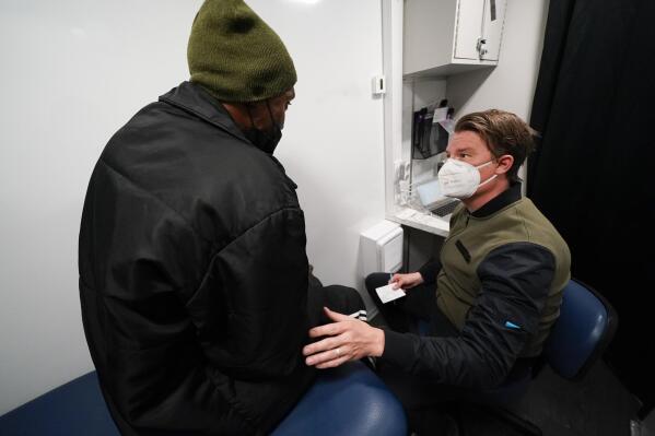 Nurse practitioner Bobby Harris, right, talks with patient Marc Floyd during a health visit inside a Baltimore City Health Department RV, Tuesday, March 21, 2023, in Baltimore. The Baltimore City Health Department's harm reduction program uses the RV to address the opioid crisis, which includes expanding access to medication assisted treatment by deploying a team of medical staff to neighborhoods with high rates of substance abuse and offering buprenorphine prescriptions. (AP Photo/Julio Cortez)