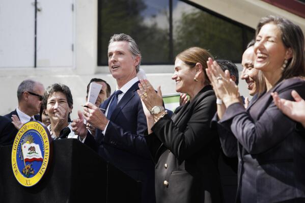 California Governor Gavin Newsom signs legislation establishing the Community Assistance, Recovery and Empowerment Act, in San Jose, Calif., Wednesday, Sept. 14, 2022. The CARE program allows family members, first responders and others to ask a judge to draw up a treatment plan for someone diagnosed with certain disorders, including schizophrenia. (Dai Sugano/Bay Area News Group via AP)